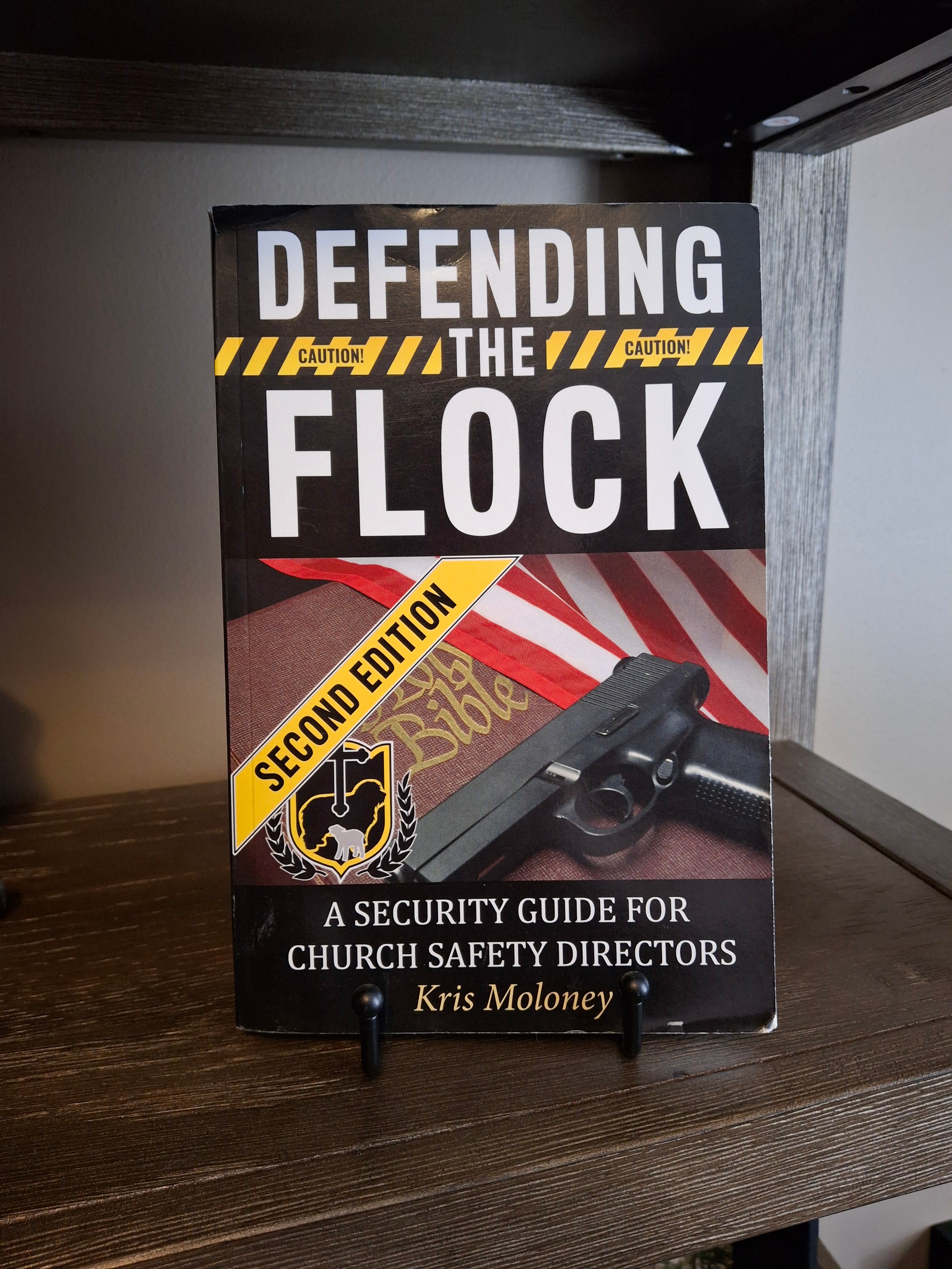 Defending the Flock Second Edition paperback church security guide for church safety directors displayed on a shelf
